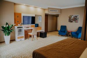 فندق إلغاردين آند ريزيدنس في ديربنت: غرفه فندقيه بسرير ومكتب وكراسي