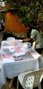 un hombre parado en una mesa con un mantel blanco en Nilenian Holiday Villas, en Jinja