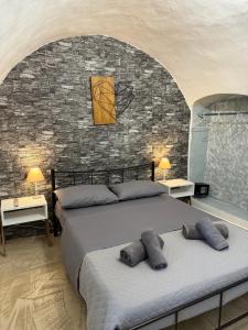 a bedroom with a bed and a brick wall at Cueva Con Vista Studios in Pirgos