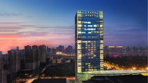 a tall building with a sign on it in a city at Grand Hyatt Shenyang in Shenyang