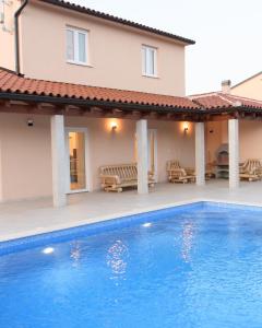 uma villa com piscina em frente a uma casa em Neue VILLA ROSE Fazana em Pula