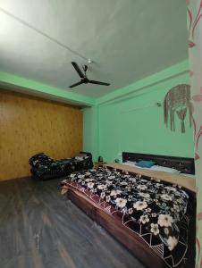 uma cama num quarto com uma ventoinha de tecto em Corridor Homestay em Sainj