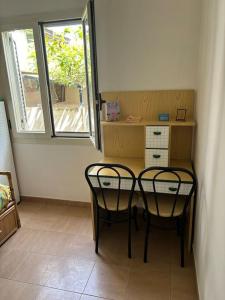 a room with two chairs and a desk with a window at Villetta con Giardino in Salerno