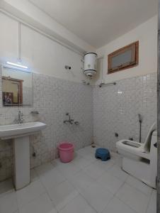 a bathroom with a sink and a toilet and a mirror at Corridor Homestay in Sainj
