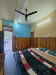 a bedroom with two beds and a ceiling fan at Corridor Homestay in Sainj