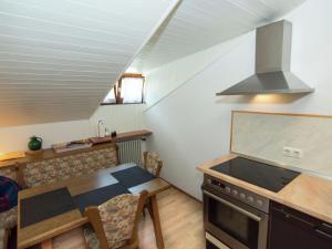 una cucina con tavolo e piano cottura forno superiore di Pleasant Apartment in Ruhpolding with Swimming Pool a Ruhpolding