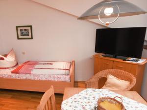 ルーポルディングにあるPleasant Apartment in Ruhpolding with Swimming Poolのベッドルーム(ベッド1台、テレビ、テーブル付)