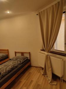 Schlafzimmer mit einem Bett und einem Fenster in der Unterkunft Apartment in the centrum with free private parking in Levice