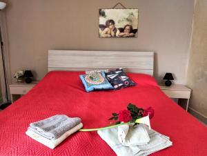 ジャルディーニ・ナクソスにあるCasa le Palmeのベッドルーム1室(赤いベッド1台、タオル付)