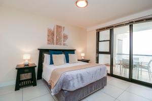 - une chambre avec un lit doté d'oreillers bleus et un balcon dans l'établissement Ocean View 304 Luxury Self Catering Apartment Strand Western Cape South Africa, au Cap 23 autres photos