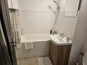 La salle de bains est pourvue d'un lavabo, d'une baignoire et de toilettes. dans l'établissement Olivia`s Studio - apartment Iasi, à Iaşi