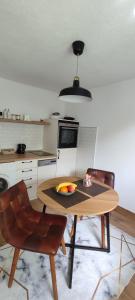 a kitchen with a table with a bowl of fruit on it at Apartman Ela in Banja Luka