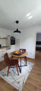 a kitchen with a table and a chair in a room at Apartman Ela in Banja Luka