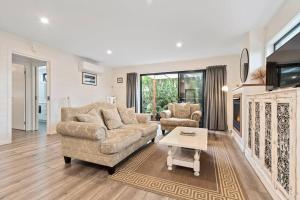 a living room with two couches and a table at Joan's Beach Cottage in Mount Martha