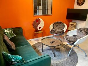 sala de estar con sofá verde y 2 sillas en Le Gîte de Brigitte !, en Saint-Dié-des-Vosges