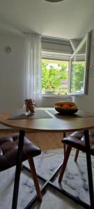 a dining room with a table and a window at Apartman Ela in Banja Luka