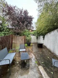 een patio met 2 tafels en stoelen en een hek bij Le cosy Balat Biel RDC jardin spacieux in Grisolles