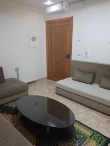 uma sala de estar com um sofá e uma mesa de centro em Lovely Paradise em Sfax