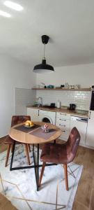 a kitchen with a table and chairs in a kitchen at Apartman Ela in Banja Luka