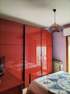 1 dormitorio con paredes rojas y 1 cama en Theo's House, en Silvi Marina