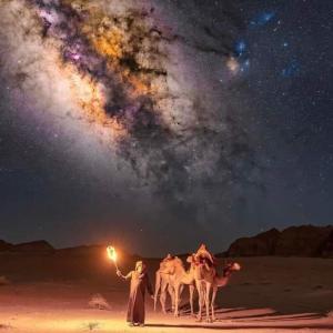 a group of people with their camels under the universe at Wadi Rum Bedouin Heart in Wadi Rum