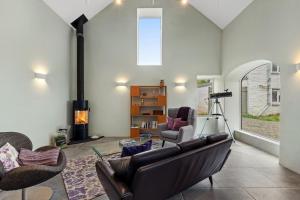 a living room with a couch and a fireplace at Luxury Stargazers Barn; Close to Coast, Town and Trails in Pembrokeshire