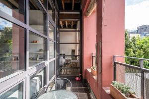 - Balcón con mesa y sillas en un edificio rosa en STYLISH APARTMENT IN CHIPPENDALE //PRIVATE PARKING, en Sídney