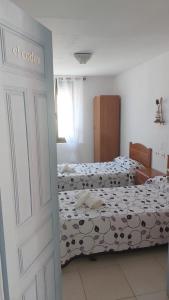 1 dormitorio con 2 camas y puerta abierta en Casadidoru, en Mansilla de las Mulas