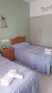 a bedroom with two beds and a dresser with towels at Casadidoru in Mansilla de las Mulas