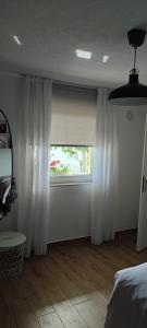 a bedroom with white curtains and a window at Apartman Ela in Banja Luka