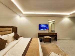 a bedroom with a bed and a desk and a tv at العليا ريزيدنس Olaya Residence in Riyadh