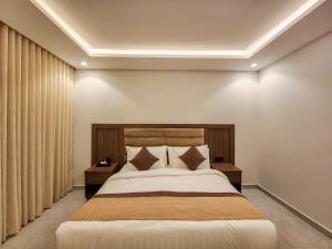a bedroom with a large bed and curtains at العليا ريزيدنس Olaya Residence in Riyadh