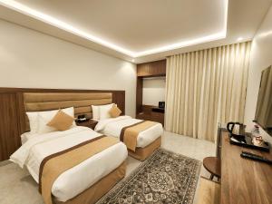a hotel room with two beds and a television at العليا ريزيدنس Olaya Residence in Riyadh
