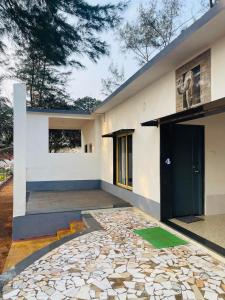 una casa con una pasarela de piedra delante de ella en The Meraki Beach Resort, en Gokarna