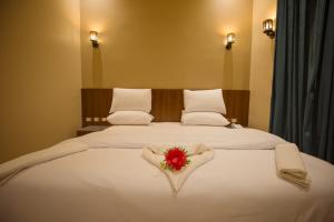 um quarto de hotel com uma cama com uma flor em Sama hotel no Cairo