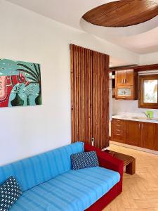 a living room with a blue couch and a kitchen at Seafront Oasis Beach Houses in Ierissos