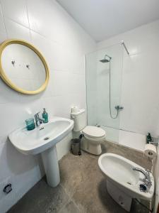 y baño con lavabo, aseo y espejo. en Pisos Baza, Tres apartmentos en Baza Central, en Baza