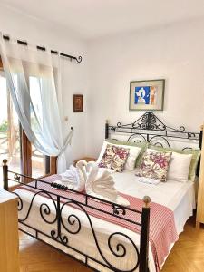a bedroom with a bed with a wrought iron frame at Seafront Oasis Beach Houses in Ierissos