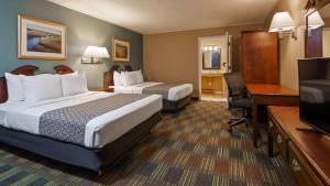 a hotel room with two beds and a desk and a television at SureStay by Best Western Cameron in Cameron