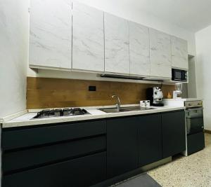 eine Küche mit schwarzen und weißen Schränken und einem Waschbecken in der Unterkunft AG SUITE TRAPANI in Trapani