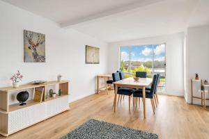 a white living room with a table and chairs at LAGOON HOUSE // POOL // PET FRIENDLY in Bellambi