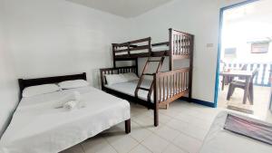 a bedroom with two beds and a bunk bed and a balcony at Galera Pension House in Balatero