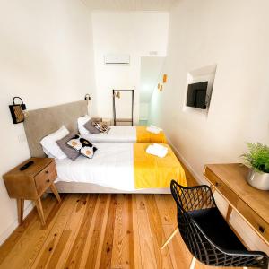 1 dormitorio con cama, escritorio y silla en Casas da Ferraria by 4U Alojamento - Tonho da Chica & Avô Marchão, en Abrantes