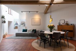 a living room with a table and a couch at In Sint Lambertus in Hasselt