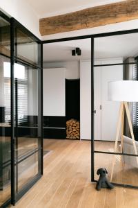a living room with glass doors and a lamp at In Sint Lambertus in Hasselt