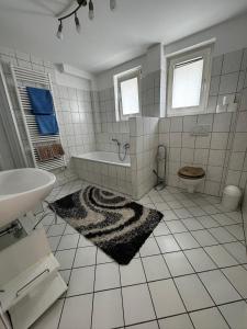 Baño blanco con bañera y lavamanos en Apartments Morneweg, en Kronberg im Taunus