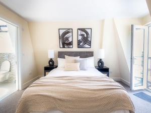 a bedroom with a large bed with two lamps at Family-Friendly 3-Bedroom Sojo Stay in London in London