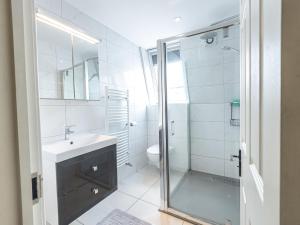 a bathroom with a glass shower and a sink at Family-Friendly 3-Bedroom Sojo Stay in London in London