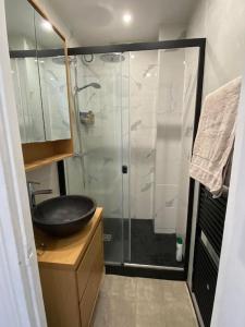 een badkamer met een glazen douche en een wastafel bij Profitez de la golden hour depuis Levallois ! in Levallois-Perret