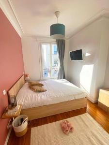 een kleine slaapkamer met een bed en een raam bij Profitez de la golden hour depuis Levallois ! in Levallois-Perret